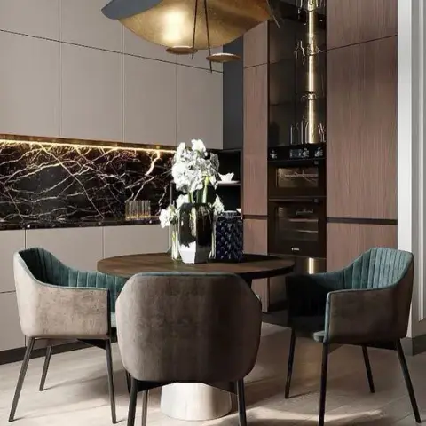 Handleless mocha-taupe kitchen with a black-and-gold marble backsplash lit by a recessed strip, a walnut oven column with a lit glass display cabinet