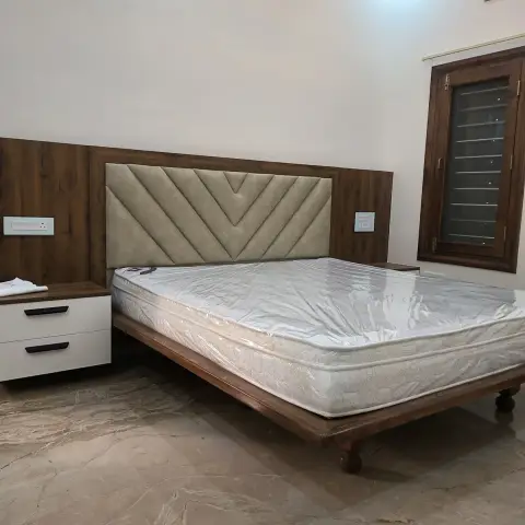 Handover-stage bedroom with a chevron-tufted beige headboard inset into a walnut laminate back panel