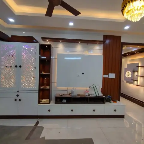 Handover-stage living room where a white TV unit runs into a backlit CNC floral-jaali pooja cabinet