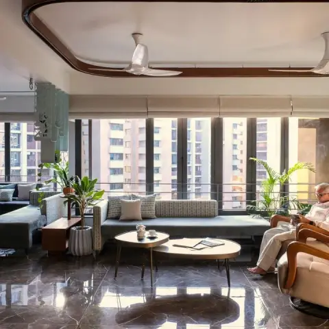 High-rise living room with a curved false ceiling edged in a wood band, a long sage window bench running under the mullioned glazing