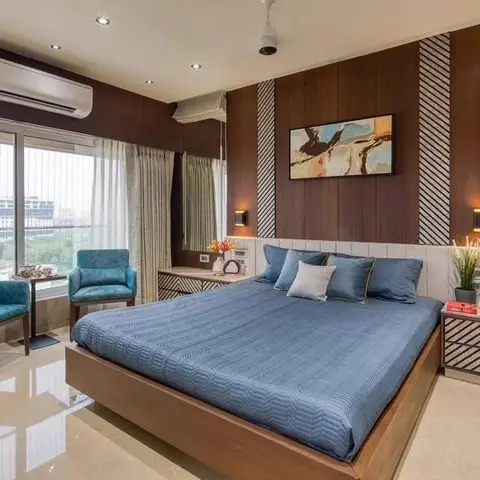 High-rise master bedroom with a striped-inlay dark wood panelled headboard wall, teal armchairs and a city-view window