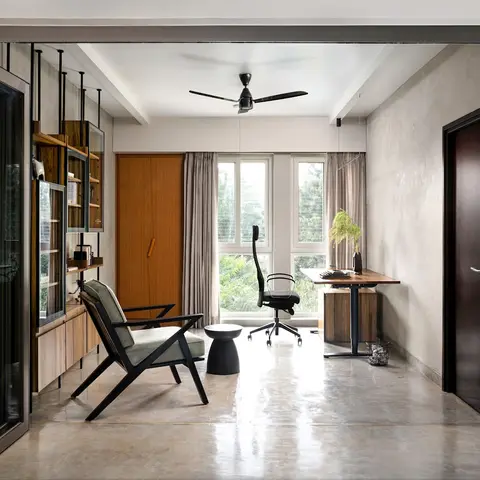 Home office with a polished-concrete floor, a wall-mounted glass-and-wood display shelf, a burnt-orange wardrobe