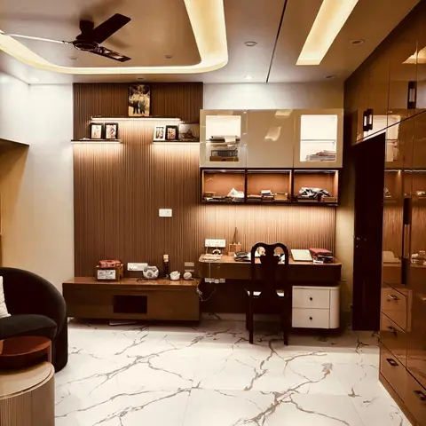 Home study nook with a fluted wood-tone feature wall, a built-in desk with glass-front display cabinets and marble flooring.