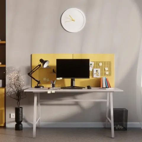 Home study nook with a white trestle-leg desk and monitor against a mustard yellow pinboard panel, flanked by open wood shelving and yellow storage cabinets.