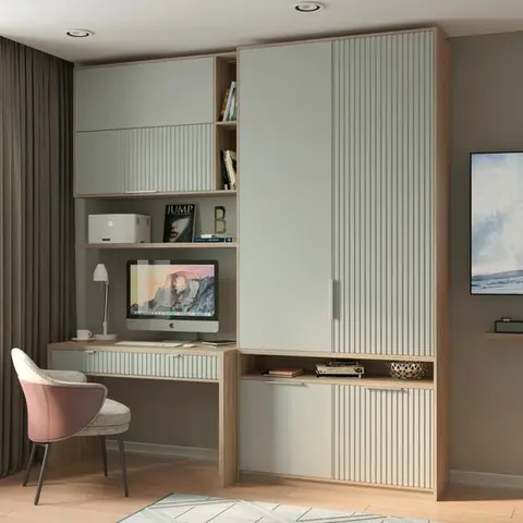 Home study with a built-in fluted-front desk and matching wardrobe unit in sage and oak, open book shelving, and a blush pink accent chair.