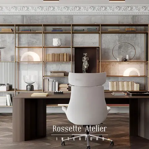 Home study with a dark wood desk facing a full-height brass-framed open shelving wall styled with books and objets
