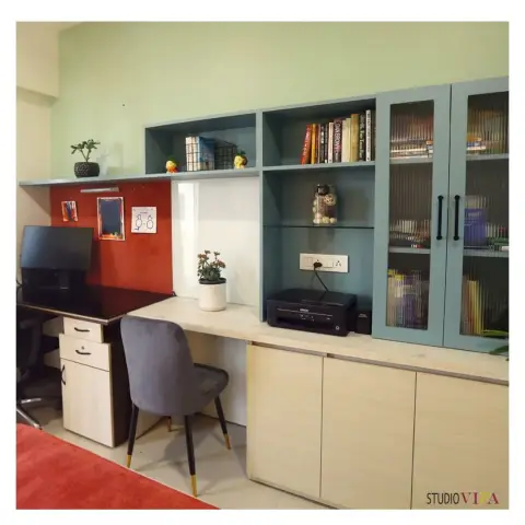 Home study with a pale-oak counter running the full wall, a terracotta pinboard panel at the monitor end