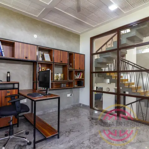 Home study with a teak-and-black-steel shelf grid over a slim desk against grey plaster walls