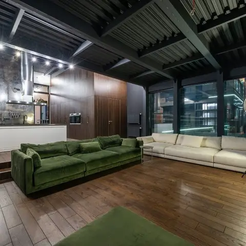 Industrial-loft living room with an exposed steel truss ceiling, floor-to-ceiling city-view windows