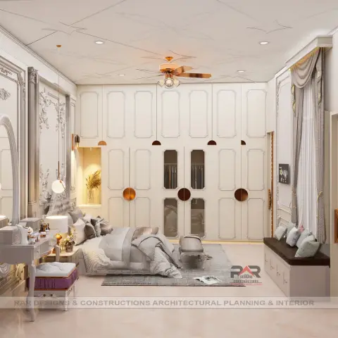 Ivory bedroom where the whole wall behind the bed is a moulded wardrobe front dotted with rose-gold disc handles and two glazed sections showing the hanging