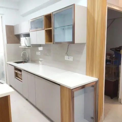 Just-installed straight-run kitchen in dove-grey matt shutters under a white quartz counter