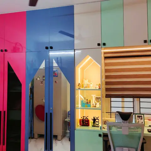 Kids' bedroom wall unit with hot-pink and blue high-gloss wardrobe shutters, a lit house-shaped display niche for toys