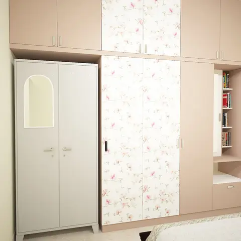 Kids' bedroom wardrobe wall with pastel-pink floral-print shutters flanking a plain grey mirrored wardrobe, plus a built-in bookshelf niche.
