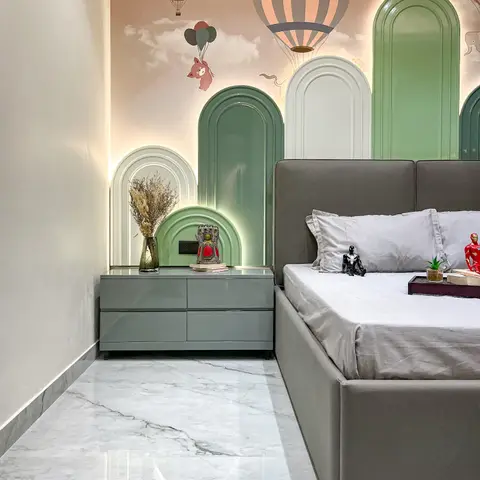 Kids' bedroom with a backlit arched panelled headboard wall in graduated sage and cream, set against a hot-air-balloon sky mural