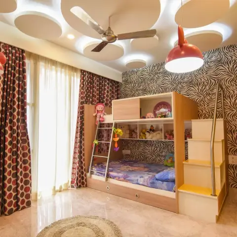 Kids bedroom with a built-in wood bunk bed with storage stairs, zebra-print wallpaper, playful Mickey Mouse-shaped pendant lights