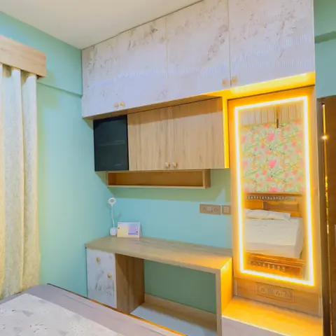 Kids' bedroom with a built-in study desk, light-oak wardrobe and marble-effect overhead lofts, a backlit LED mirror, and mint-green walls