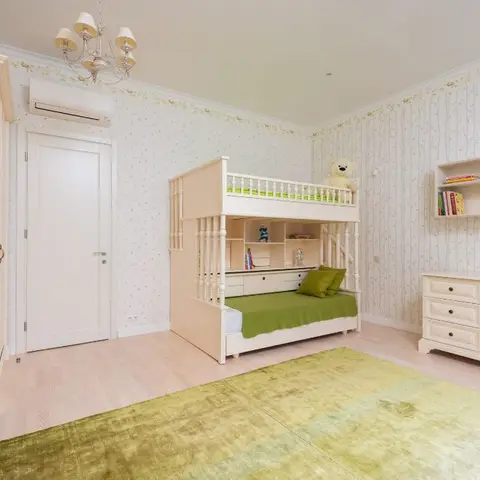Kids bedroom with a cream built-in bunk bed with storage stairs, a floral vine wallpaper, and a green shag rug