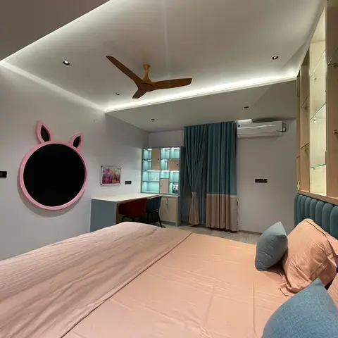 Kids bedroom with a peach and teal palette, a pink bunny-shaped wall mirror, a channel-tufted teal headboard