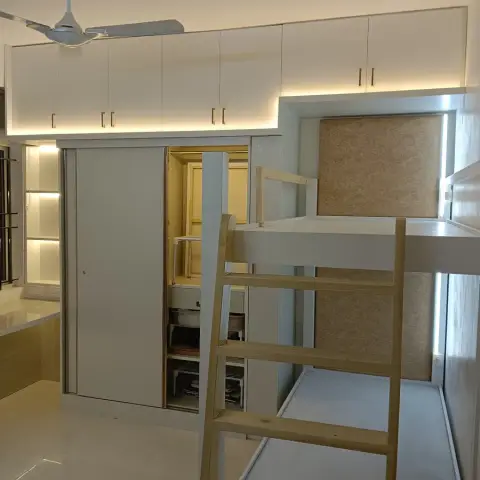 Kids' bedroom with a white loft bed and integrated sliding wardrobe beneath, accessed by a wood ladder.