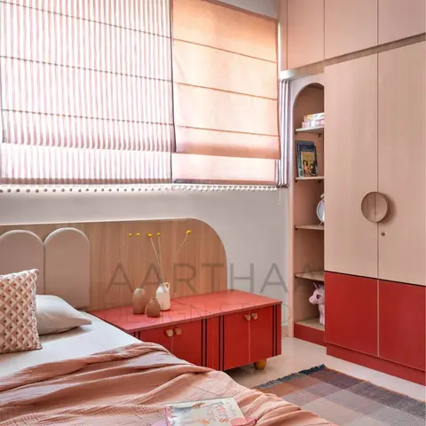 Kids' bedroom with an arched pink-and-wood headboard, a red-and-blush built-in wardrobe with a stuffed unicorn peeking from an open shelf