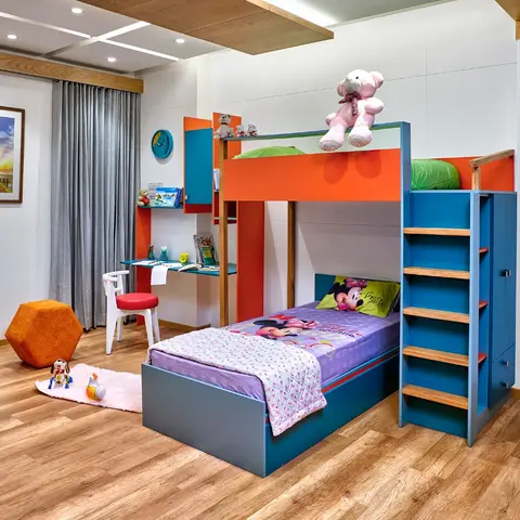 Kids bunk bed room in blue and orange with a built-in study desk and ladder to the upper berth.