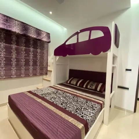 Kids' room built around a white bunk unit whose upper berth is screened by a purple car-silhouette cut-out panel