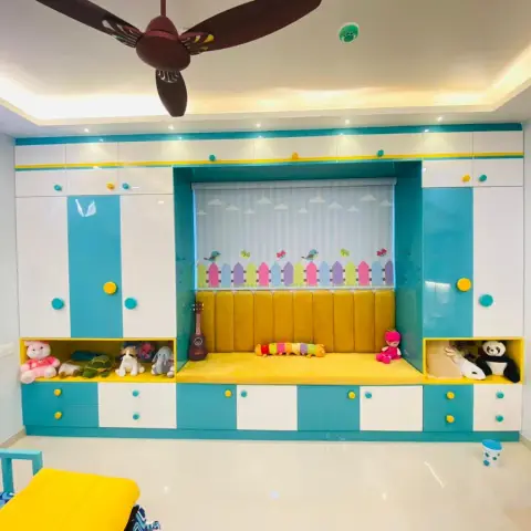 Kids' room storage wall in turquoise, white and yellow with round pastel knobs, wrapping a mustard fluted-cushion window seat lined with soft toys and a