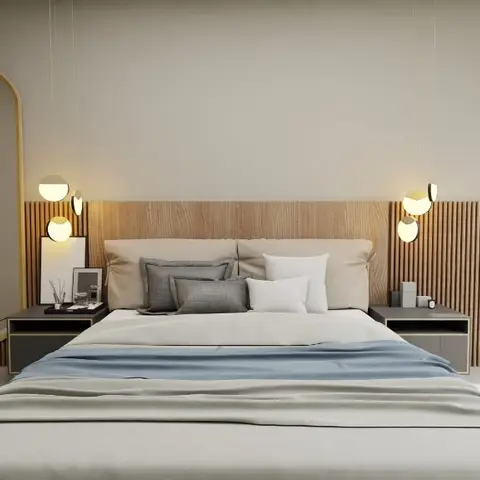 King bed dressed in grey and blue linen against a fluted wood-panelled headboard wall, flanked by cluster pendant lights and an oval brass-framed mirror.