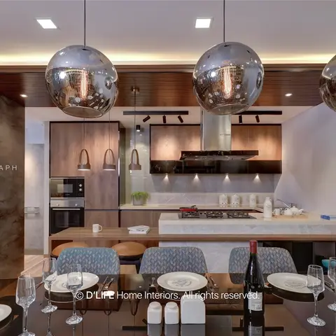 Kitchen-dining nook with three smoked-glass globe pendant lights over a marble island, dark stone accent wall, table set for dinner