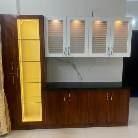 Kitchen dry counter with a backlit glass crockery display column, wood-grain base cabinets, striped-glass wall units, and a marble-effect backsplash.