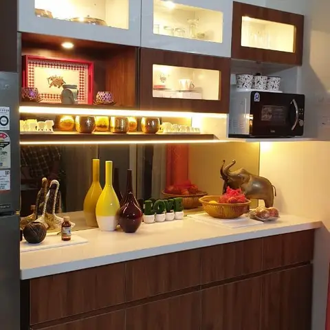 Kitchen dry-pantry counter with white and walnut-finish glass-shutter display cabinets lit from within