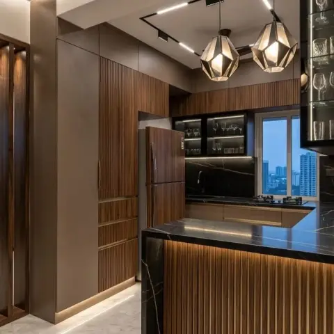 Kitchen island with a black marble waterfall countertop, vertical fluted wood cabinetry, geometric pendant lights and a built-in glass-front display cabinet