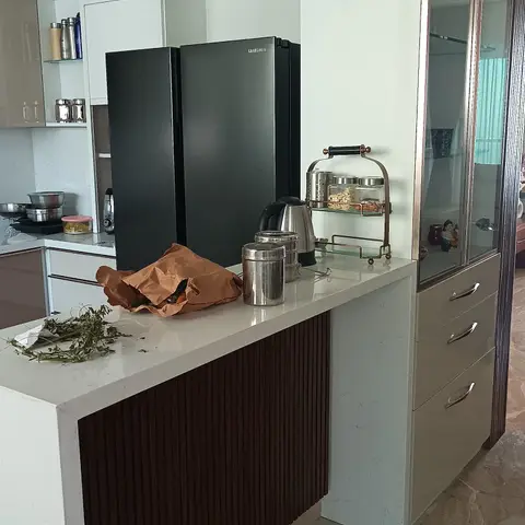 Kitchen pass-through counter with a fluted dark-wood apron and a matching glass-front crockery cabinet