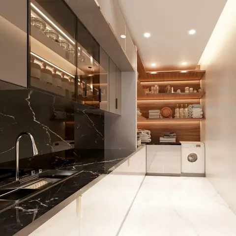 Kitchen with a black marble countertop and backsplash leading into a wood-shelved utility nook with a washing machine.