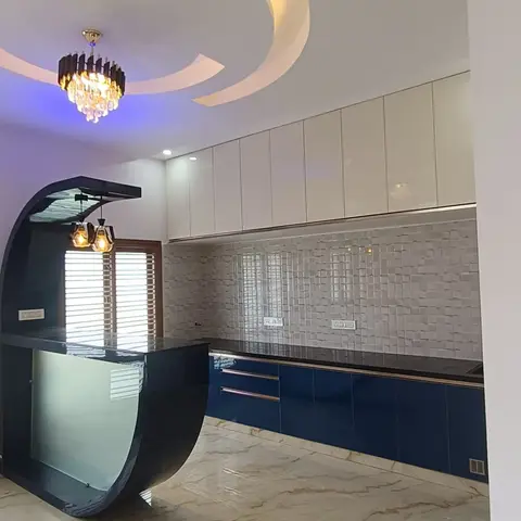 Kitchen with glossy navy-blue base cabinets, a curved frosted-glass breakfast bar, mosaic backsplash tile, and a colour-changing cove-lit curved false ceiling.