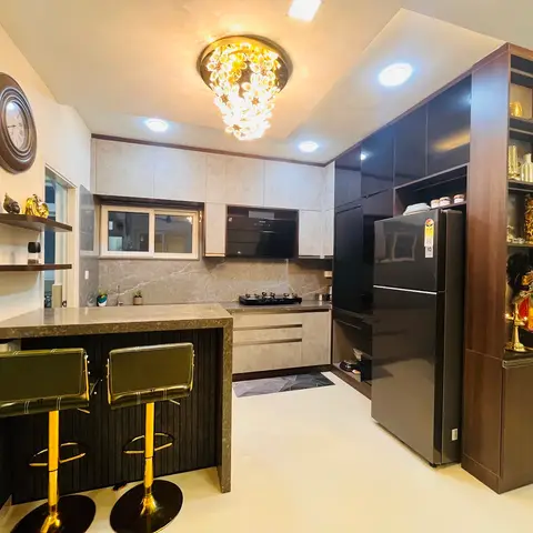 L-shaped kitchen with a stone-topped breakfast counter and gold-legged bar stools, grey marble-effect backsplash