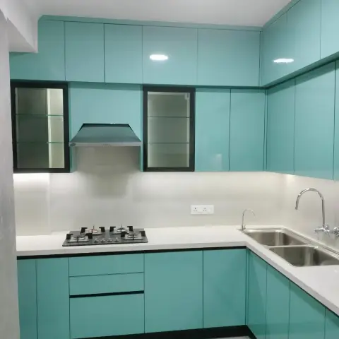 L-shaped kitchen with glossy turquoise cabinets, glass-front display units flanking the chimney hood
