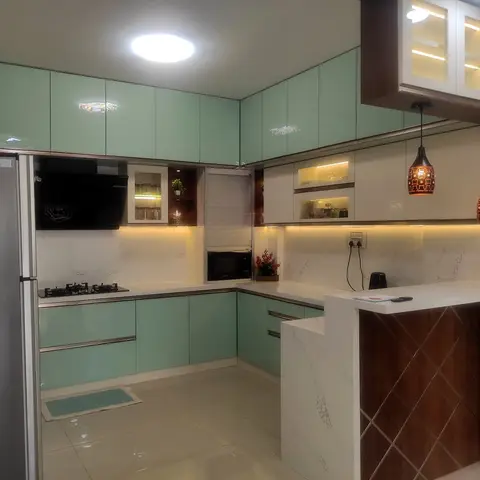 L-shaped modular kitchen with glossy mint cabinets, a marble-look counter and backsplash, a lit glass display cabinet