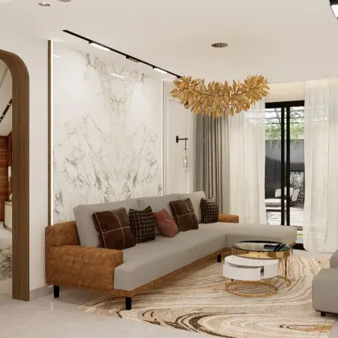 L-shaped sofa in grey fabric with tan suede arms sits against a bookmatched white-and-gold marble slab wall