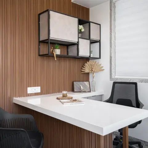 L-shaped study desk with fluted wood cladding and a white quartz top, set against a matching fluted-panel wall with a floating storage cubby.