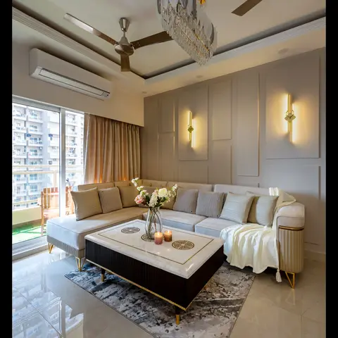 L-shaped upholstered sofa facing a marble-and-brass coffee table, with linear wall sconces on panelled walls and a high-rise balcony view.