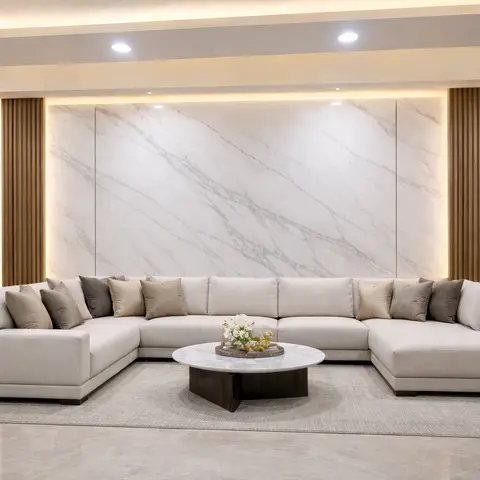 Large living room with a beige U-shaped sectional sofa facing a backlit white marble feature wall flanked by vertical fluted wood panelling
