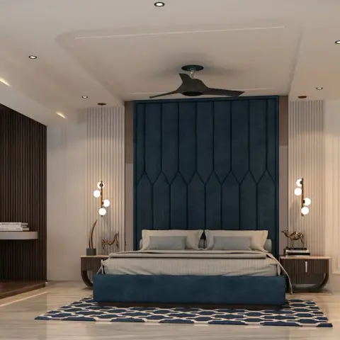 Large primary bedroom with a tall navy channel-tufted headboard flanked by twin globe wall sconces, a fluted wood accent wall with a built-in seating nook