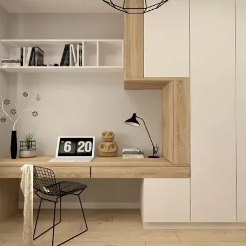 Light-oak floating desk running the full window wall into a matt white full-height storage block, styled with a flip clock