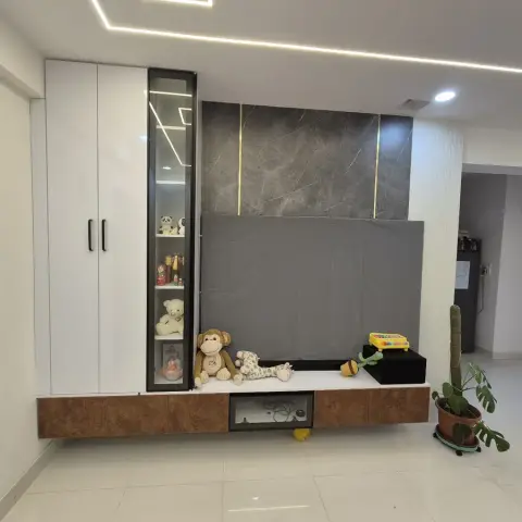 Lived-in hall where the TV sits under a grey dust sheet against a grey marble slab with brass inlay lines