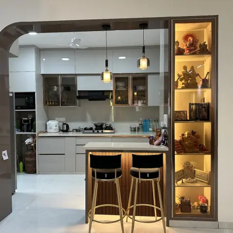 Lived-in open kitchen framed by a curved dark high-gloss arch, with a fluted-wood breakfast counter and two black bar stools in front
