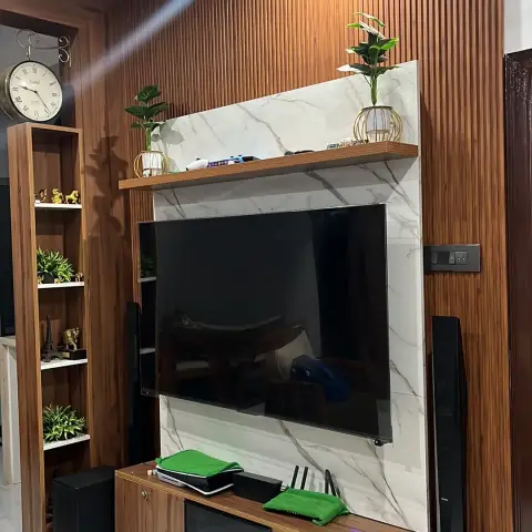 Lived-in TV wall in fluted teak laminate with a white marble-look tile centre panel