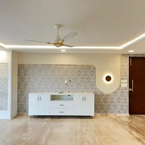Living area with a grey damask wallpaper feature wall behind a white gloss console, a circular backlit wall light beside the dark wood main door