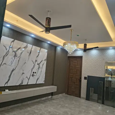 Living area with a large book-matched marble TV feature wall, a floating white console