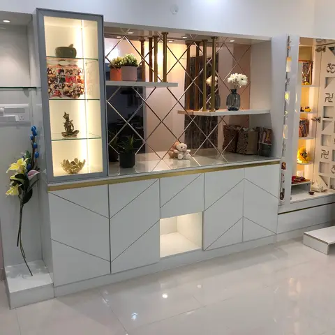 Living/entrance divider unit combining a glass-front curio display case, a diamond mirror-panelled console with a brass rod screen